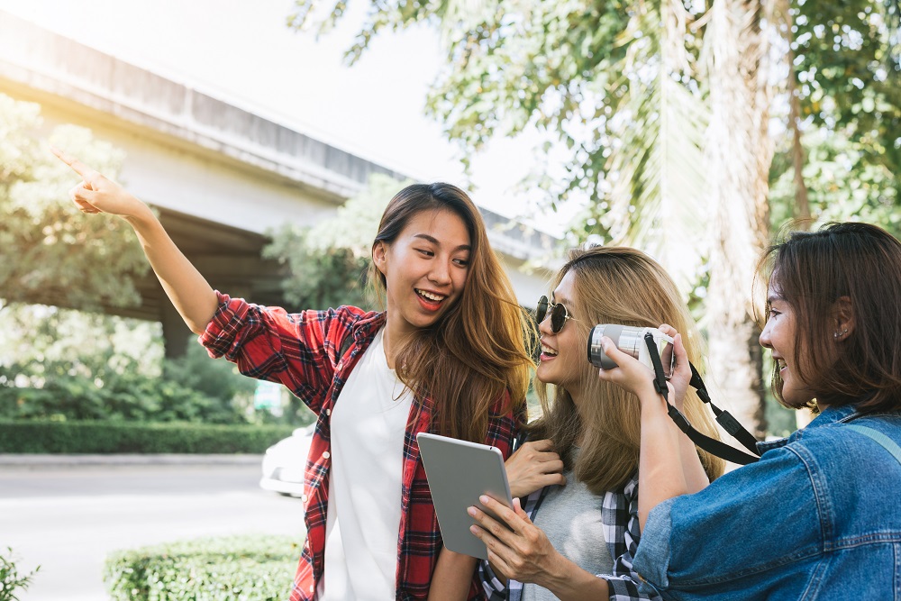 Group of Asian women using camera to make photo while traveling