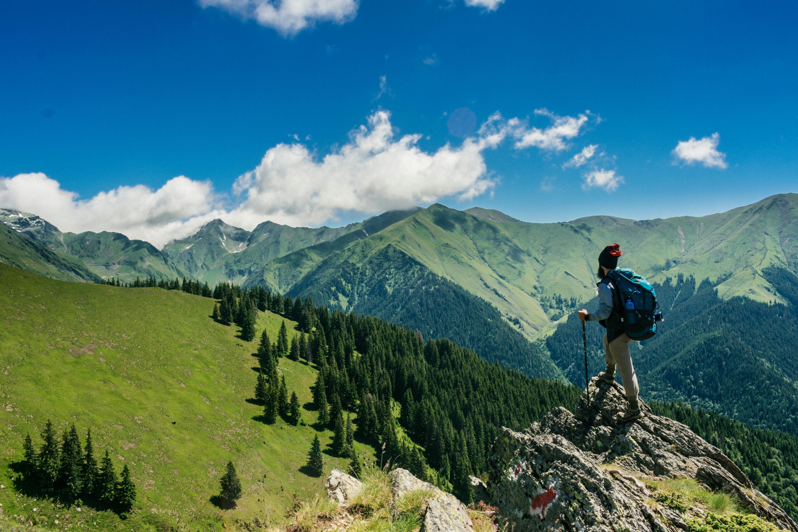 Adventurous hiker enjoying breathtaking views of lush green mountains