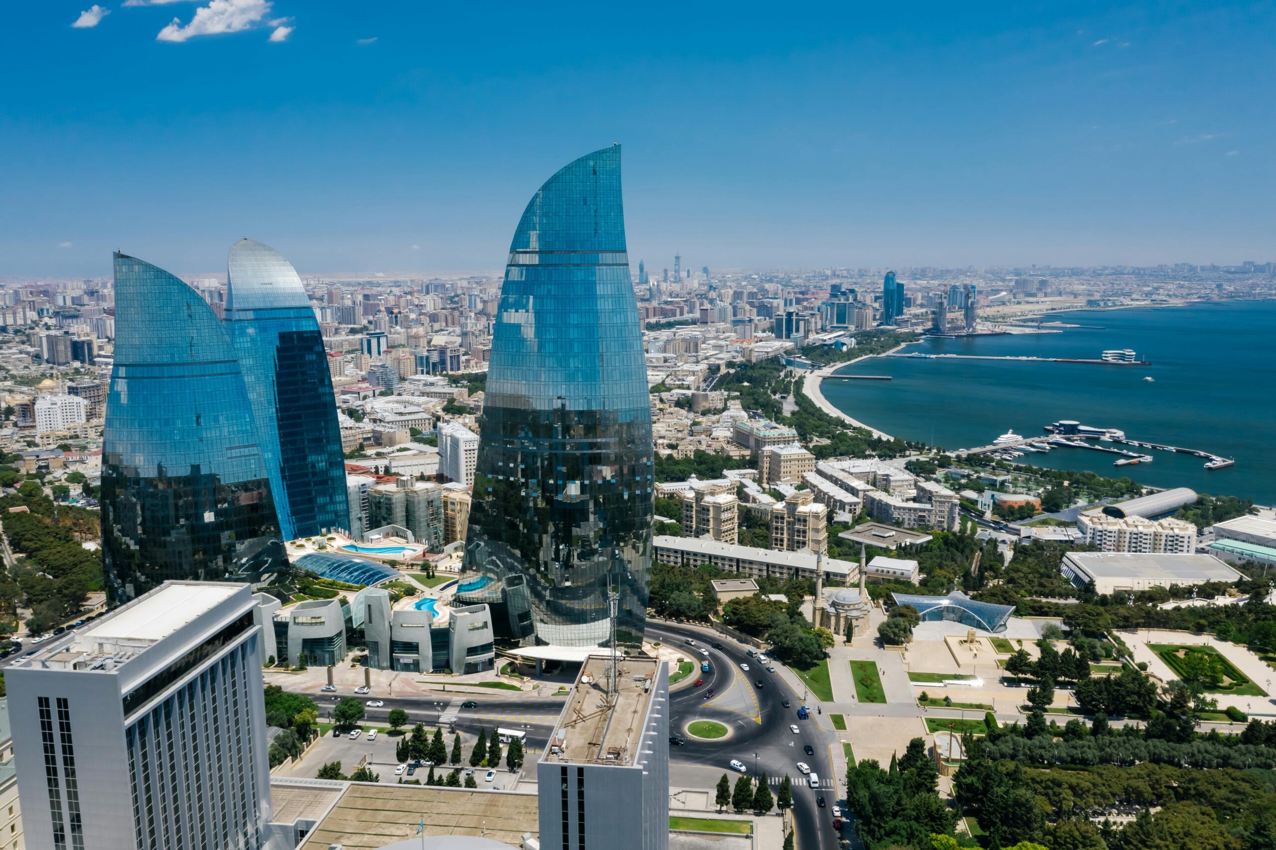 Stunning aerial view of Baku's Flame Towers with the Caspian Sea in the backdrop.