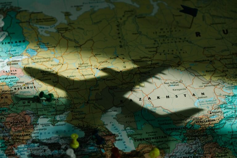 Sombra de un avión de juguete sobre un mapa detallado de Europa del Este que destaca Kazajistán.