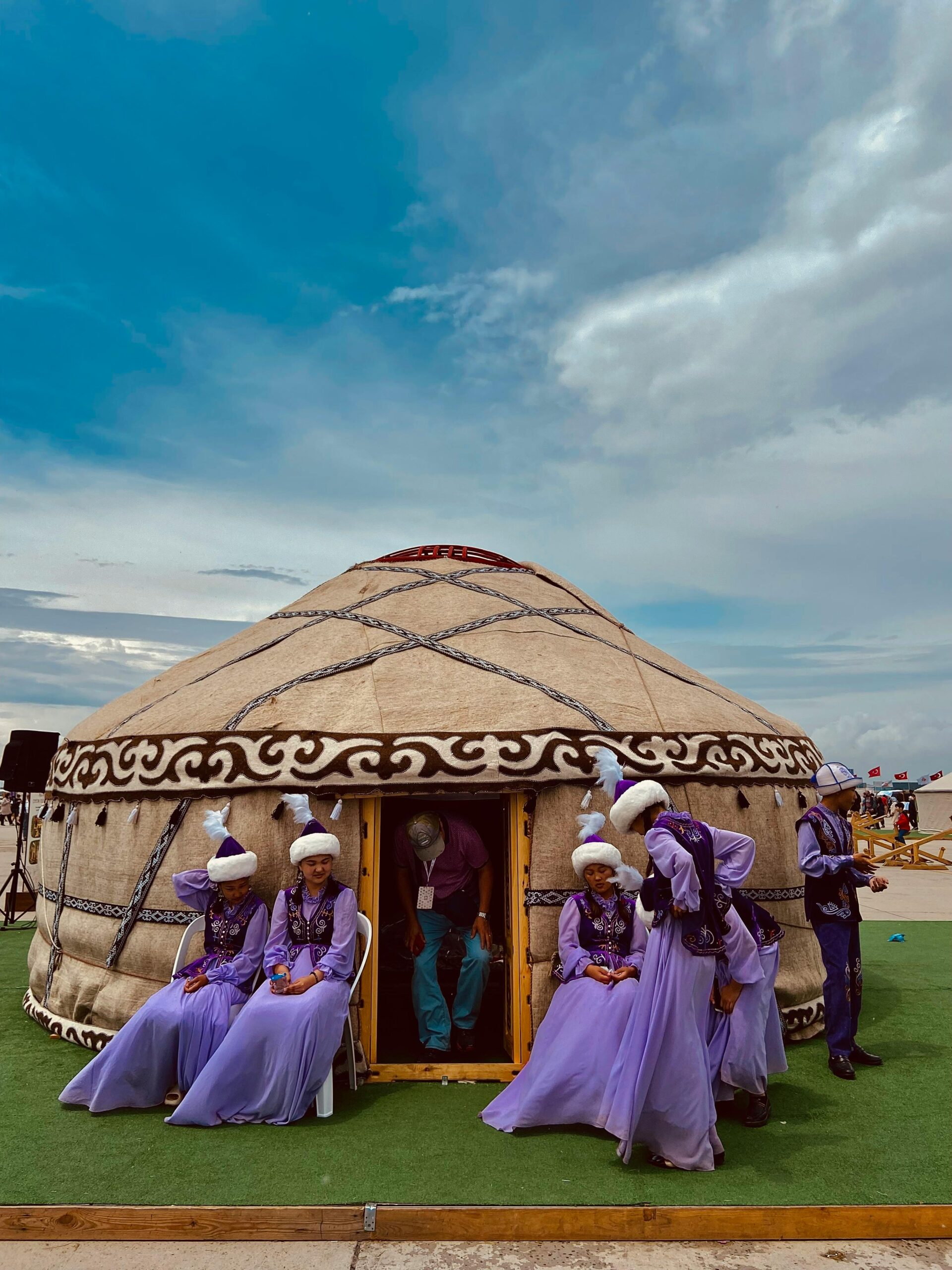 A vibrant scene of traditional attire against a yurt backdrop at a cultural event in İstanbul, Türkiye.