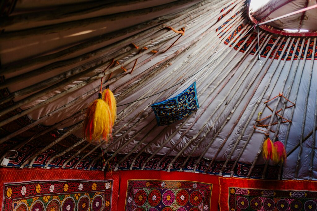 Explore the colorful and traditional interior design of a Mongolian yurt featuring intricate patterns and textiles.