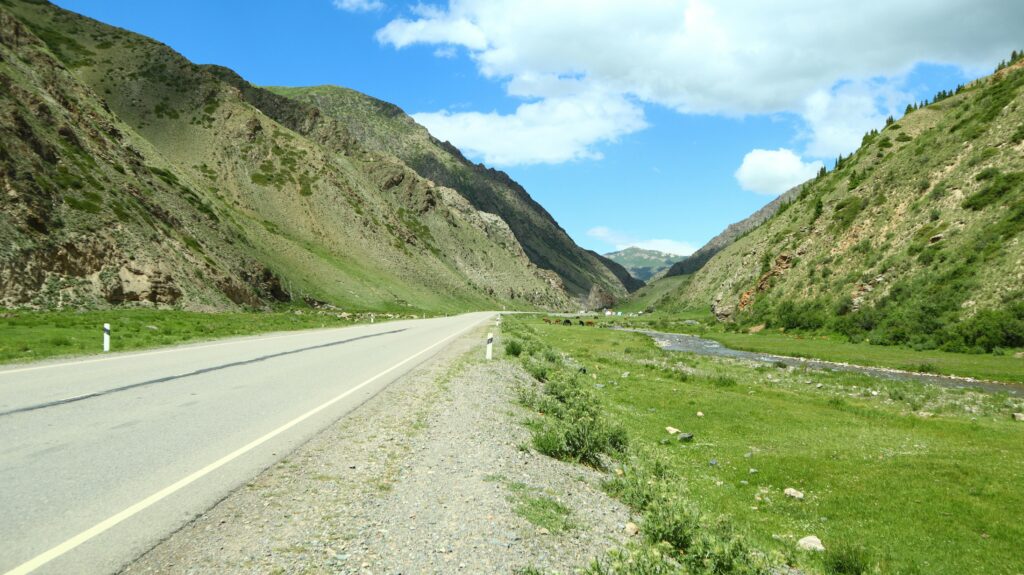 A tranquil road through the scenic mountains of Naryn Valley, Kyrgyzstan.