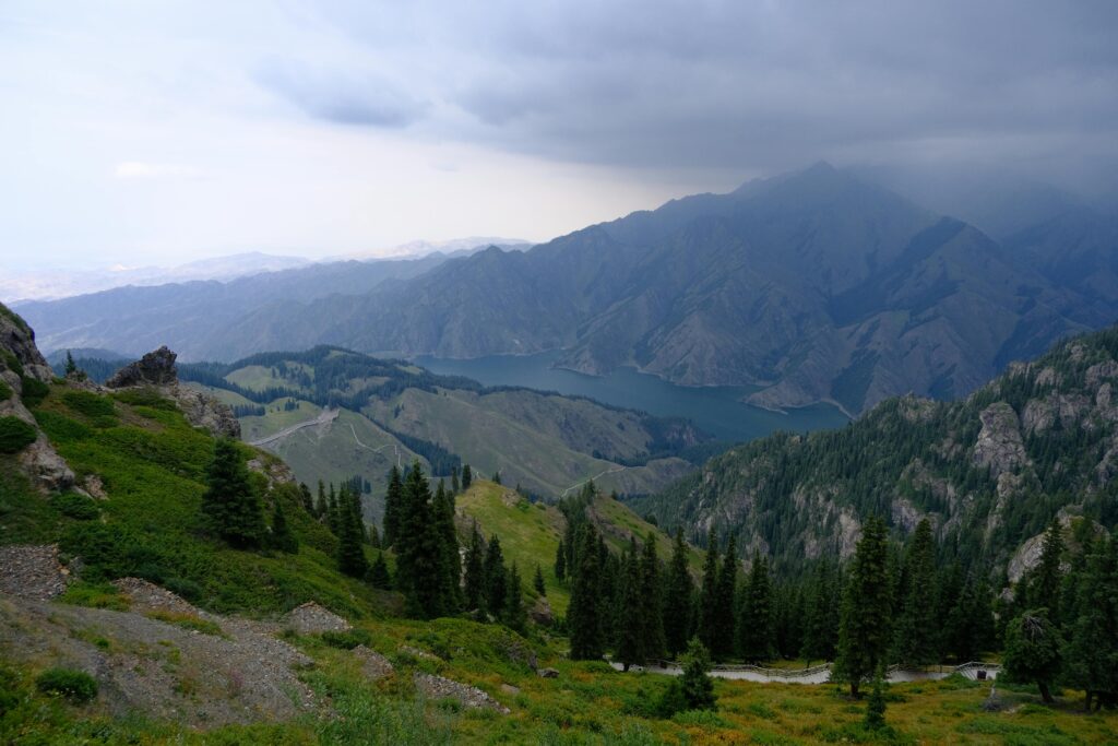 Scenic landscape of Sary-Chelek Lake surrounded by majestic mountains and lush greenery in Kyrgyzstan.