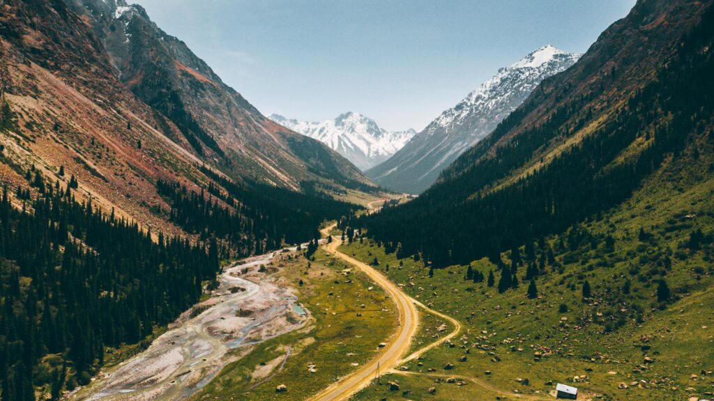A breathtaking view of Jety-Oguz Valley with winding roads and snow-capped mountains.