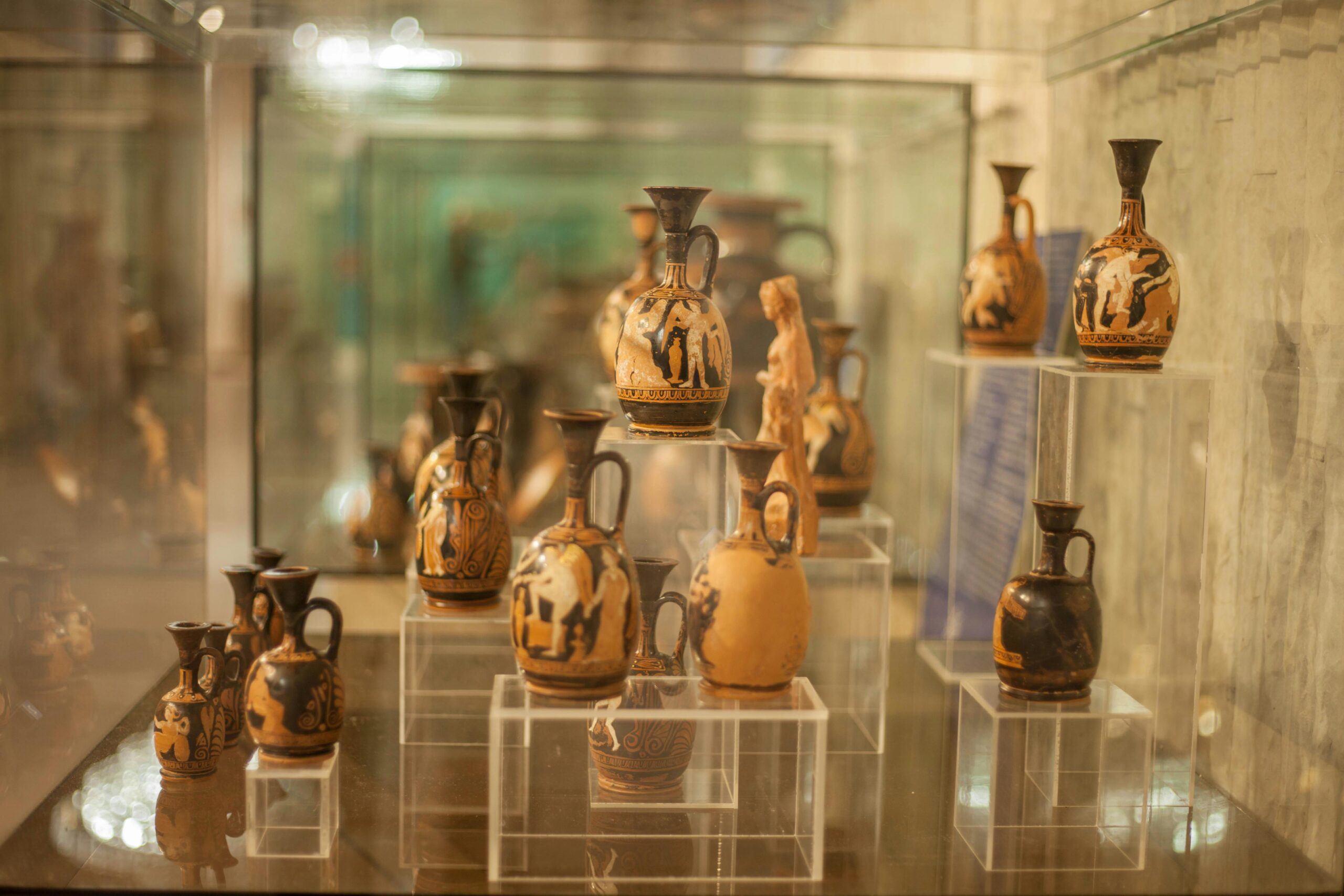 Showcase of ancient Greek pottery artifacts in a museum setting.