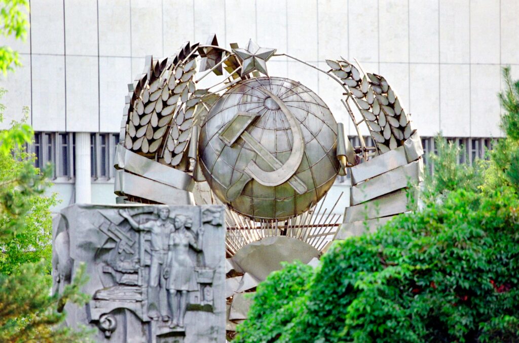 A detailed view of a Soviet sculpture in Moscow, showcasing historical symbolism amidst greenery.