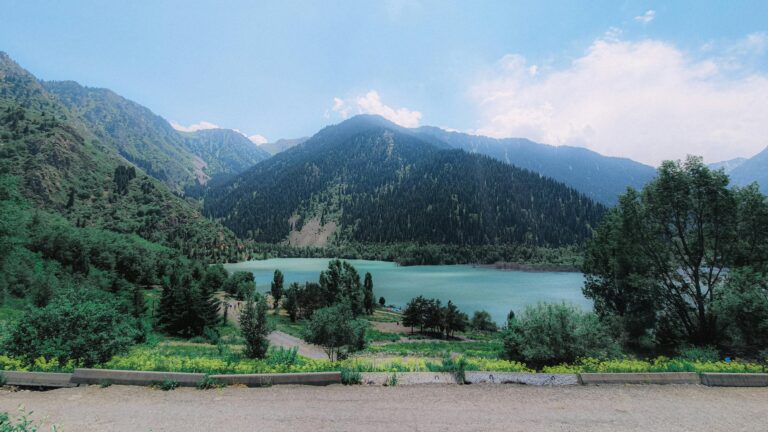 Breathtaking summer landscape of Lake Issyk, surrounded by lush mountains in Kazakhstan.