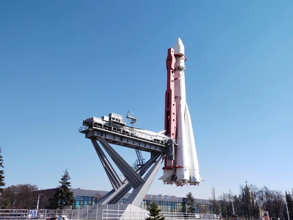 A Soyuz rocket is displayed at Moscow's VDNKh against a clear blue sky.