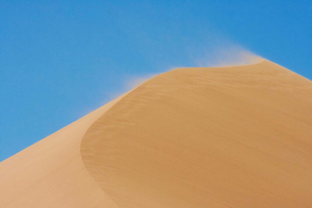 Captivating view of a sand dune against a clear blue sky in Altyn-Emel National Park, Kazakhstan.