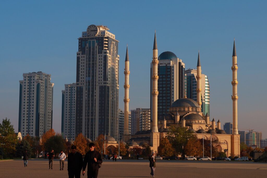 Stunning view of skyscrapers and mosque in urban landscape during sunset.