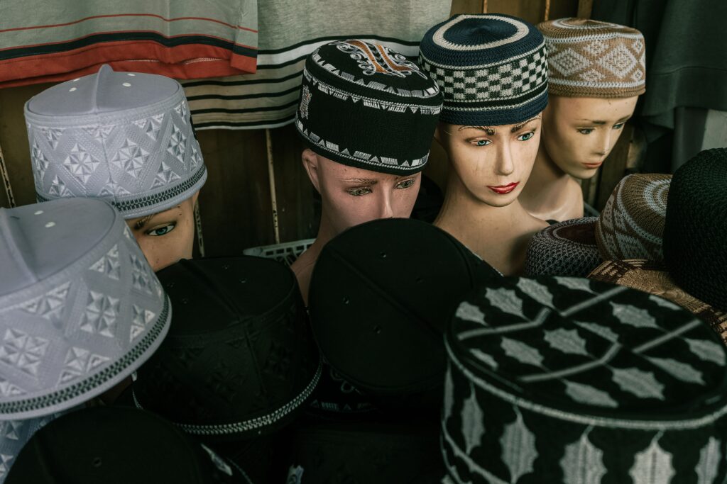 Collection of traditional Indonesian caps displayed on mannequins in Bandung, showcasing cultural fashion.