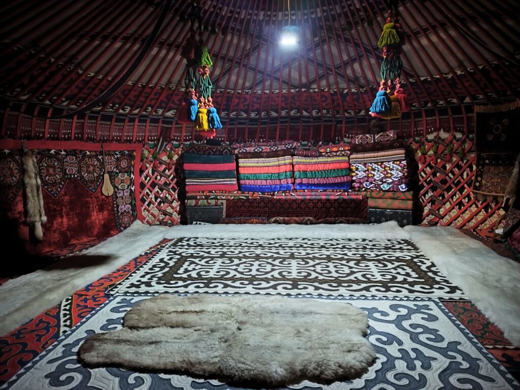 Cozy interior of a traditional yurt adorned with vibrant textiles and cultural decor.