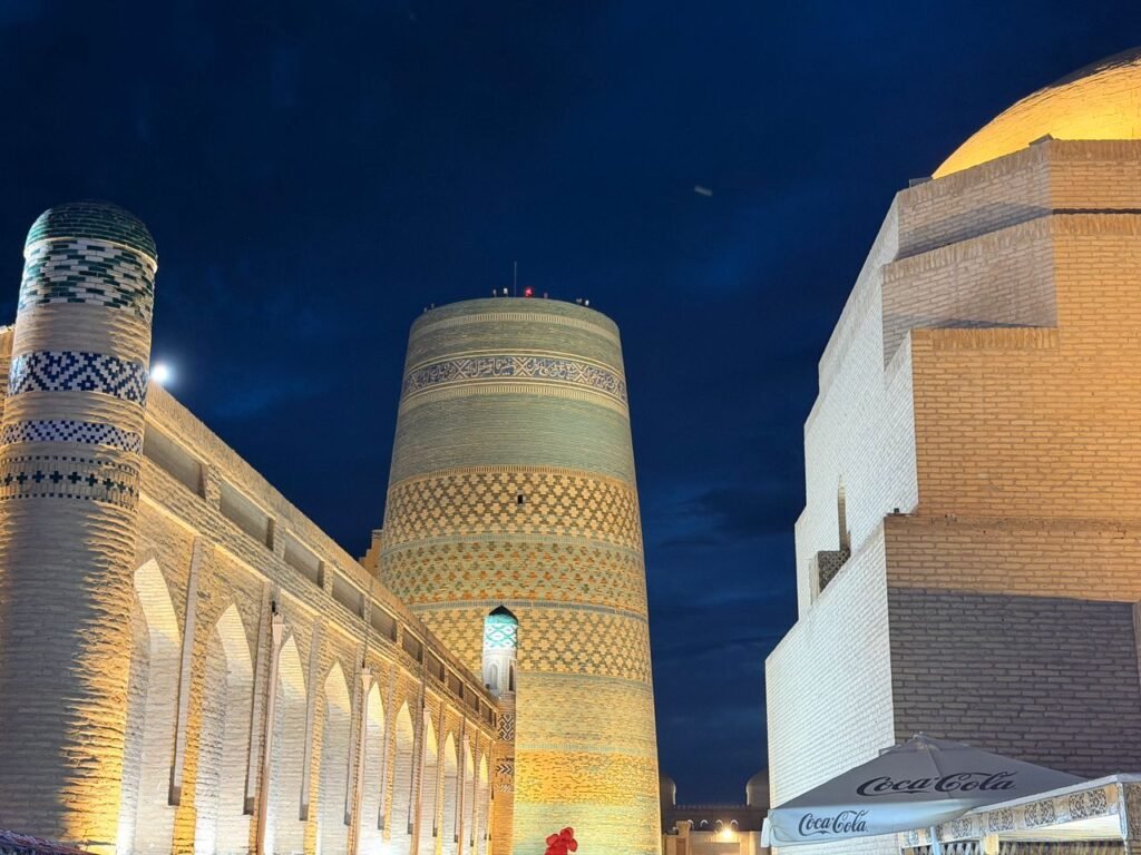 Captivating night view of the illuminated Kalta Minor Minaret in Khiva, Uzbekistan. Historical architecture under a starlit sky.